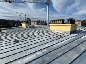 Remplacement d’une couverture en amiante par une toiture en zinc à joint debout avec isolation en laine de verre et pose d’un Velux de désenfumage